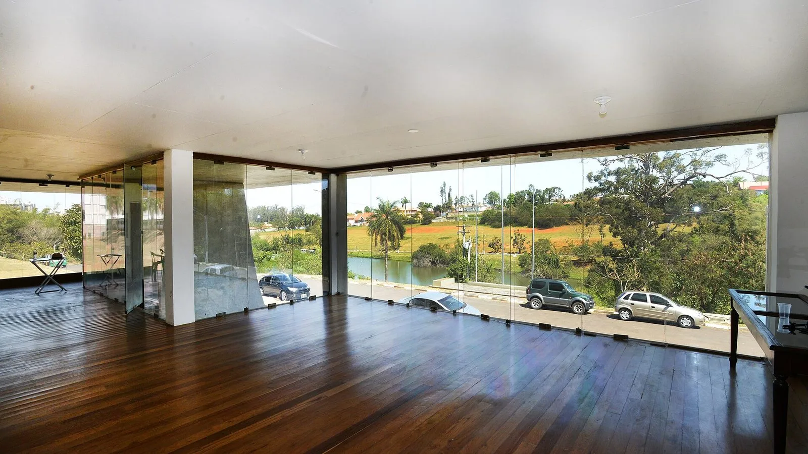O salão da Casa de Vidro, sede do Museu da Cidade, com vista para a área verde do Lago do Café.