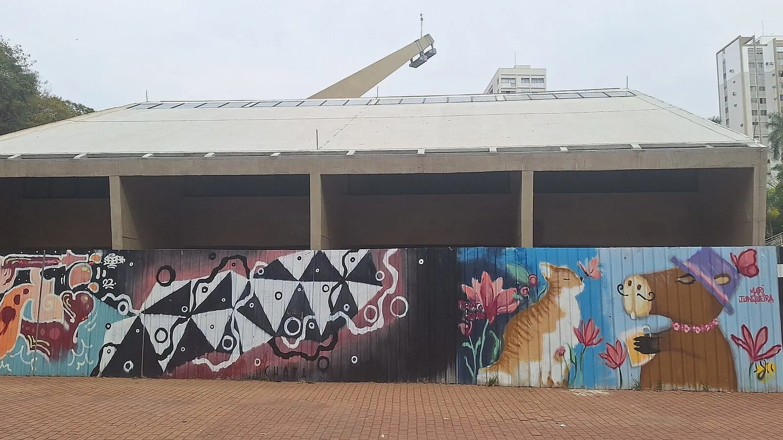 Prédio do Centro de Convivência Cultural de Campinas, com cobertura de concreto e tapume grafitado à frente