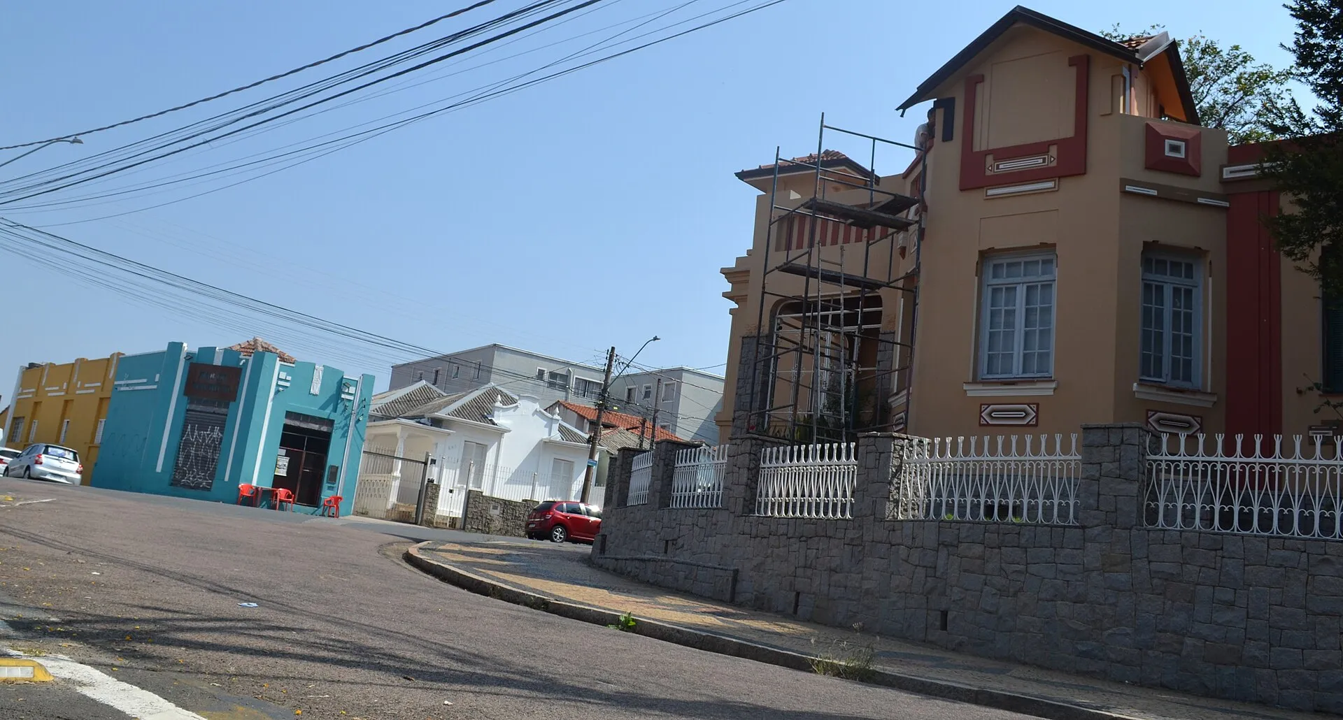 Rua da Vila Industrial com edifícios históricos e via urbana sob luz do dia