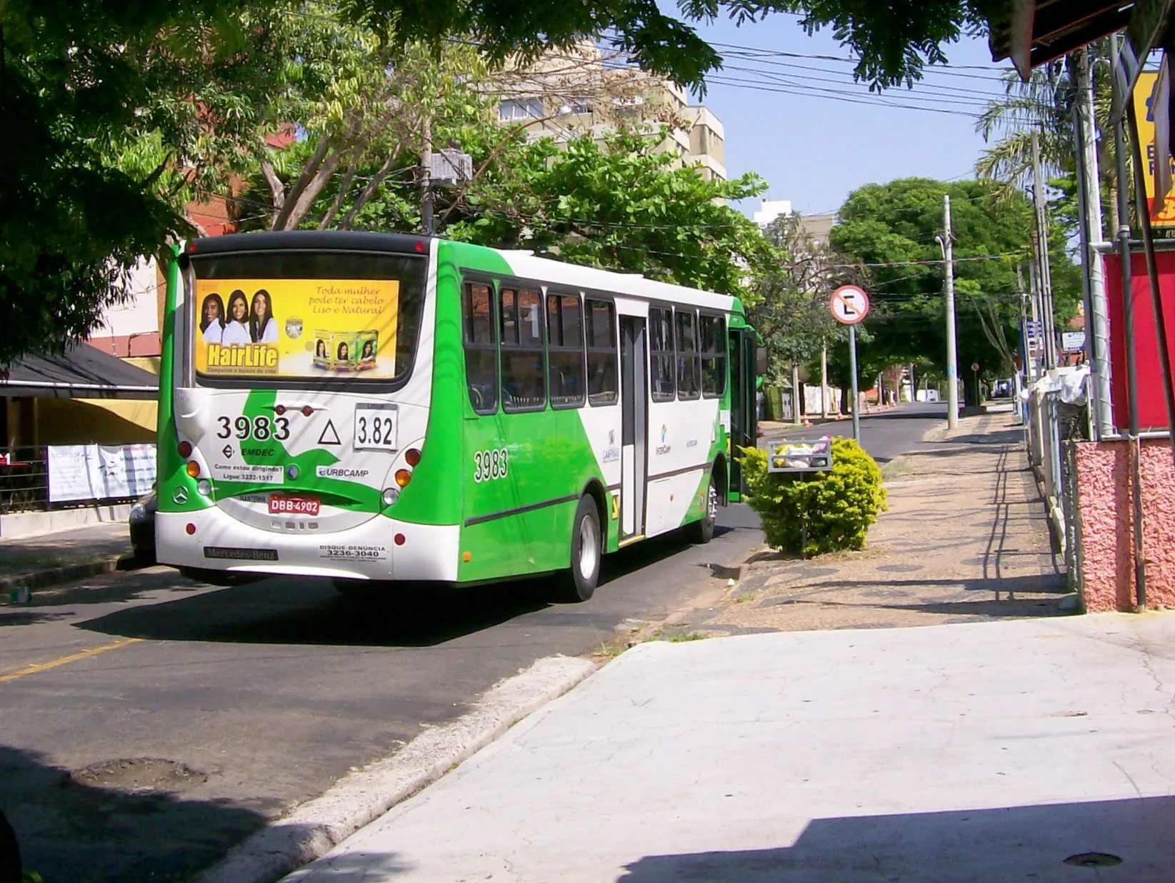 Ônibus verde e branco do Intercamp em rua de Campinas com árvores ao fundo