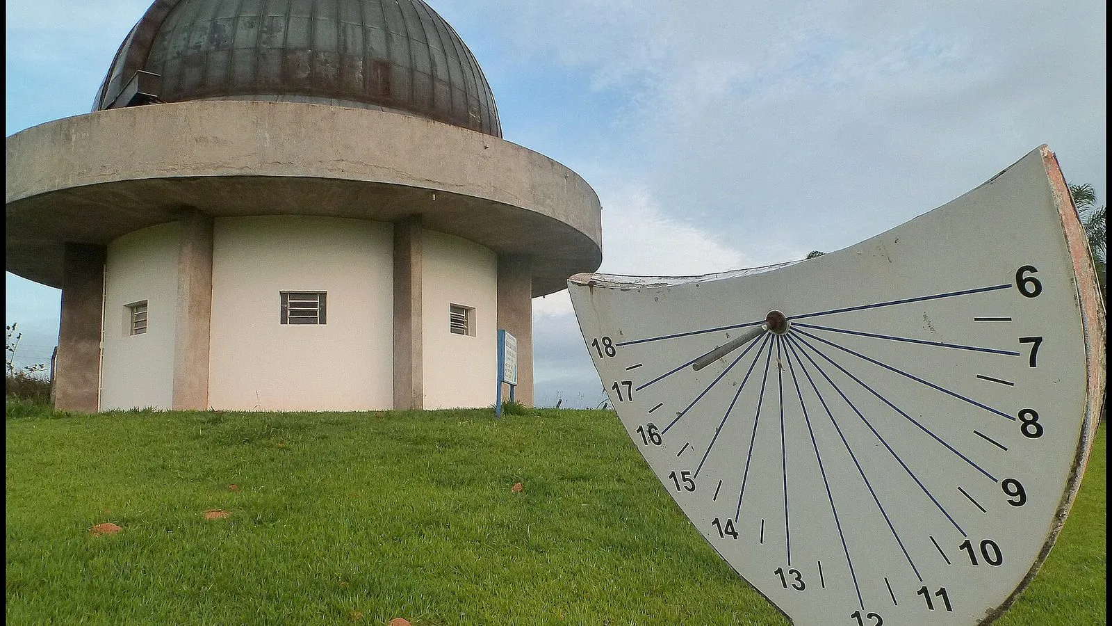 Prédio redondo com cúpula metálica do Observatório Municipal Jean Nicolini, em Joaquim Egídio, ao lado de um relógio de sol no gramado