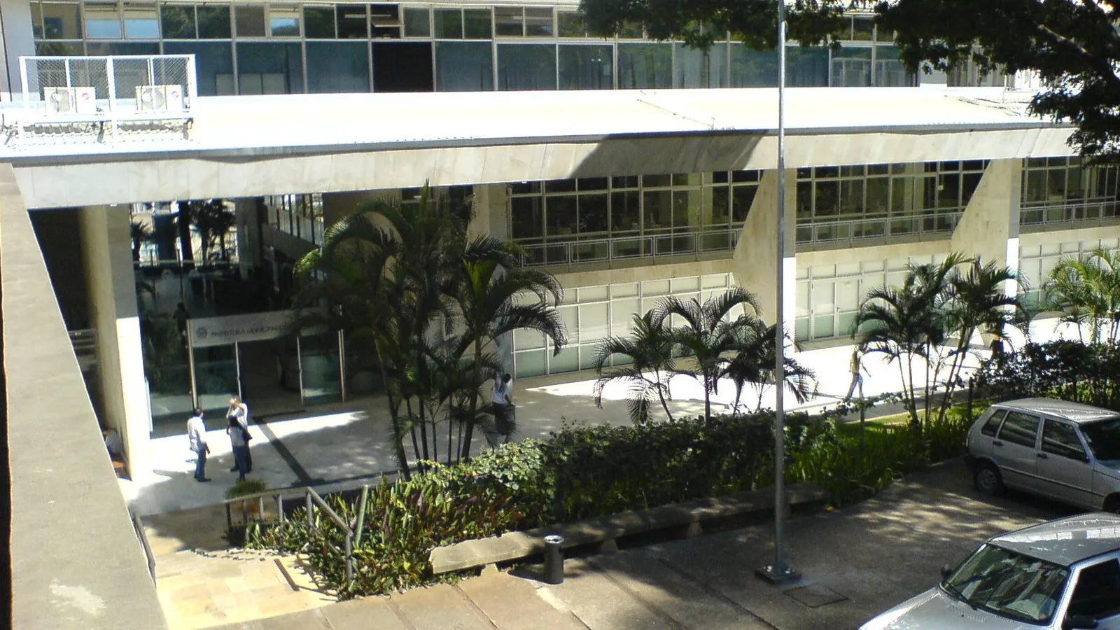 Entrada do Paço Municipal de Campinas, na Avenida Anchieta, com palmeiras e jardim na frente do prédio
