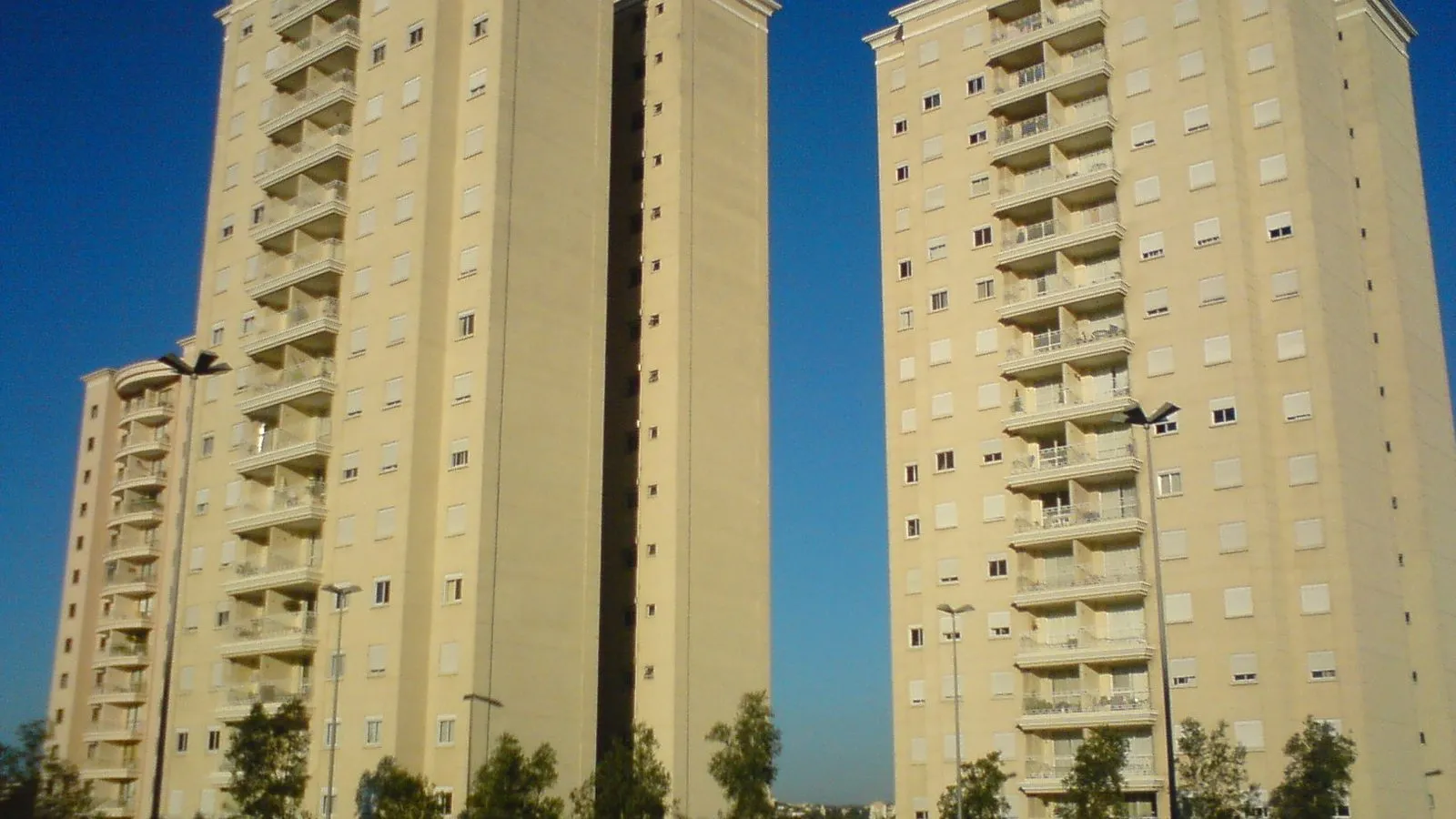 Duas torres residenciais de apartamentos com varandas no Jardim Aurélia, em Campinas, sob céu azul