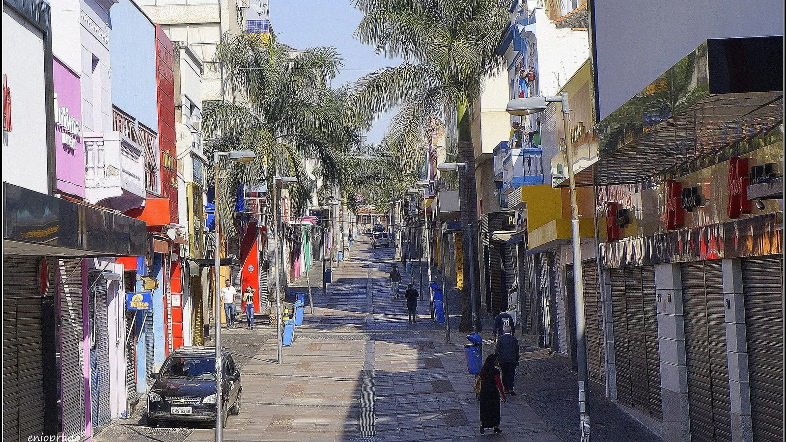 Calçadão da Rua 13 de Maio, no Centro de Campinas, com palmeiras, postes e lojas de portas fechadas numa manhã de sol